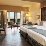 twin beds, terrace and a table at the deluxe room lagoon view at fanar hawana salalah oman