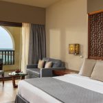 a double bed and a terrace with a sun bed at fanar hotel deluxe room in hawana salalah oman