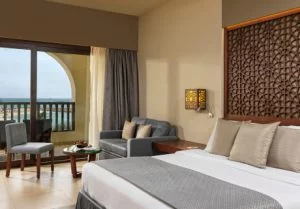 a double bed and a terrace with a sun bed at fanar hotel deluxe room in hawana salalah oman