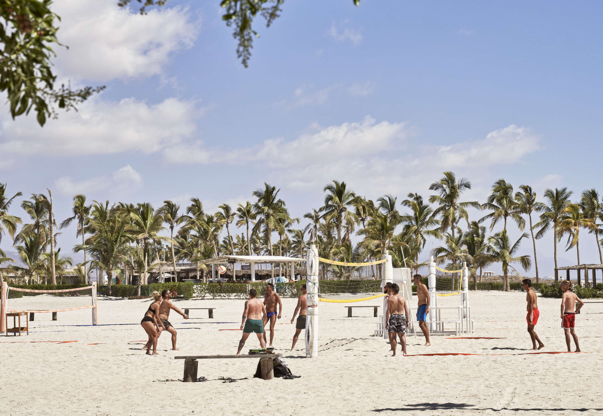 group of friends playing beach volleyball in hawana salalah beach 
