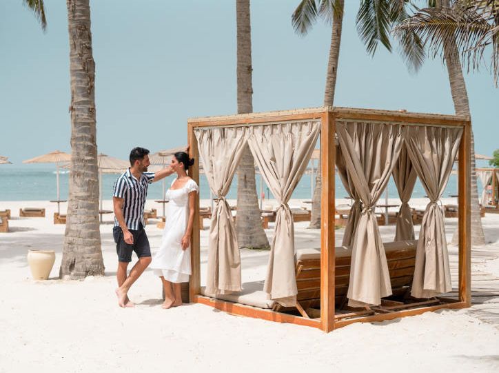 romantic couple on white sandy beach in oman