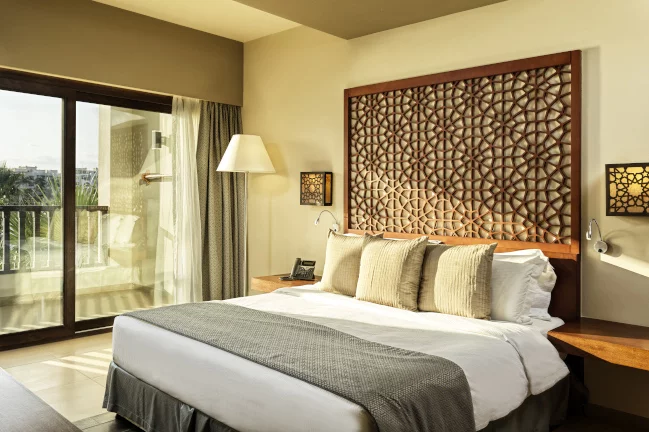 a king bed and a terrace with a view at the fanar marina suite in hawana salalah