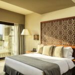 a king bed and a terrace with a view at the fanar marina room in hawana salalah