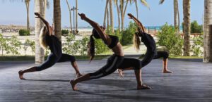 girls doing yoga on the beach as a background at at fanar resort in hawana salalah oman