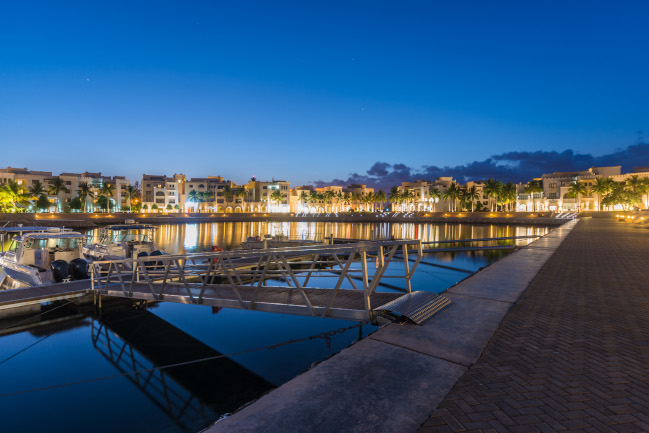 hawana salalah marina area during night with fanar hotel buildings in the background 