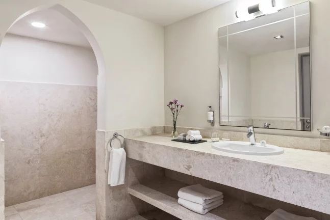 sink and walk in shower inside one bedroom apartments in fanar hotel and residences in hawana salalah
