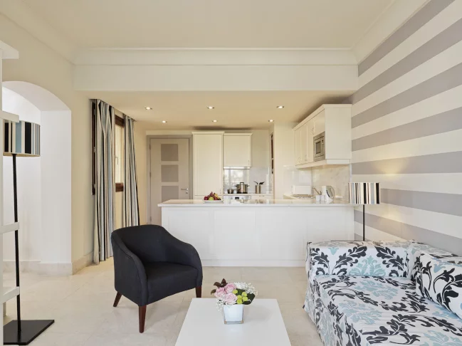 couch, chair and a kitchenette at the one bedroom apartment at fanar resort in hawana salalah oman