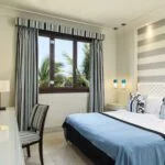 a double bed, chair by the window at the one bedroom apartment at fanar resort in hawana salalah oman