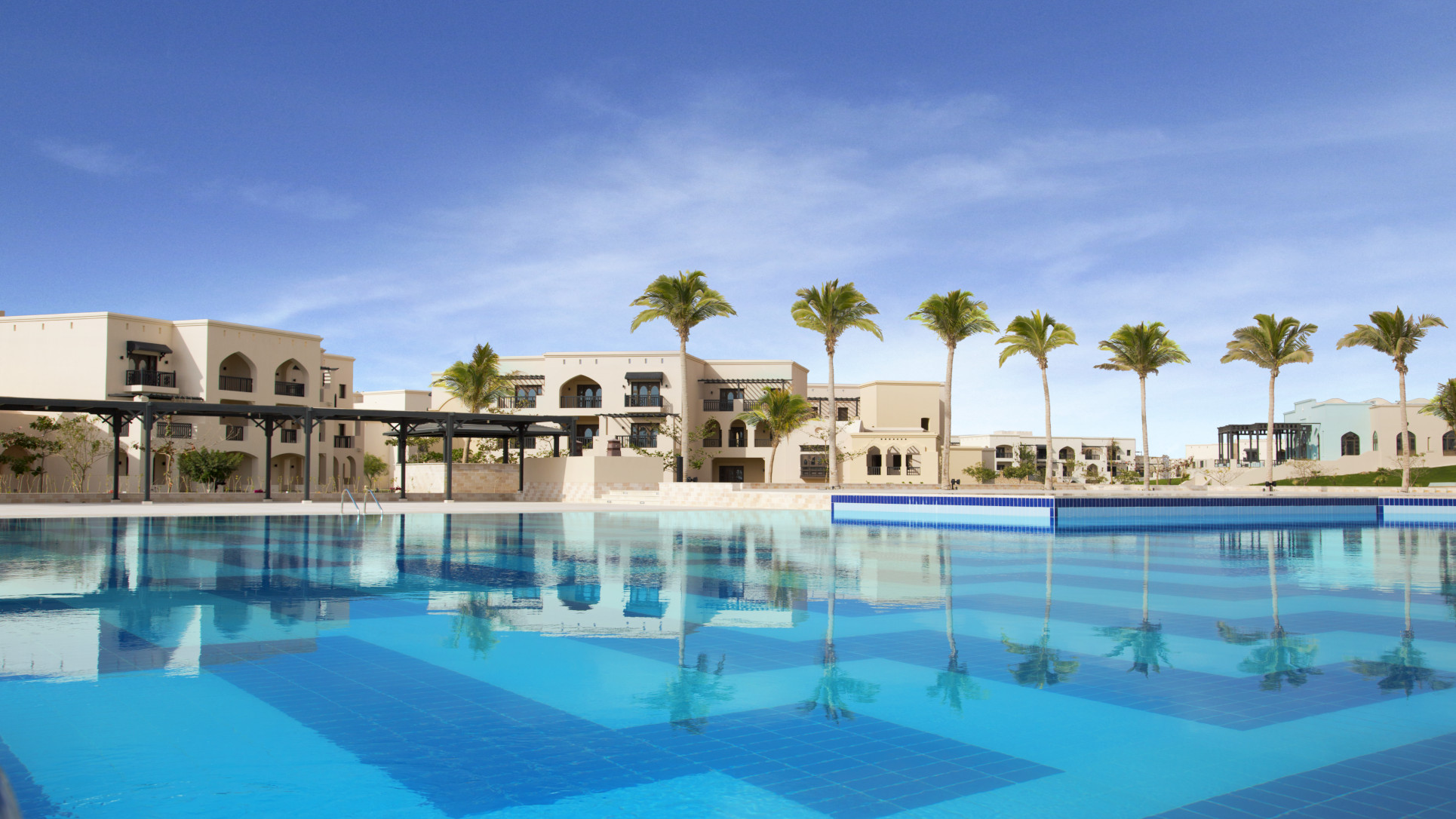 Salalah Rotana Swimming Pool with Sky and Palms. 