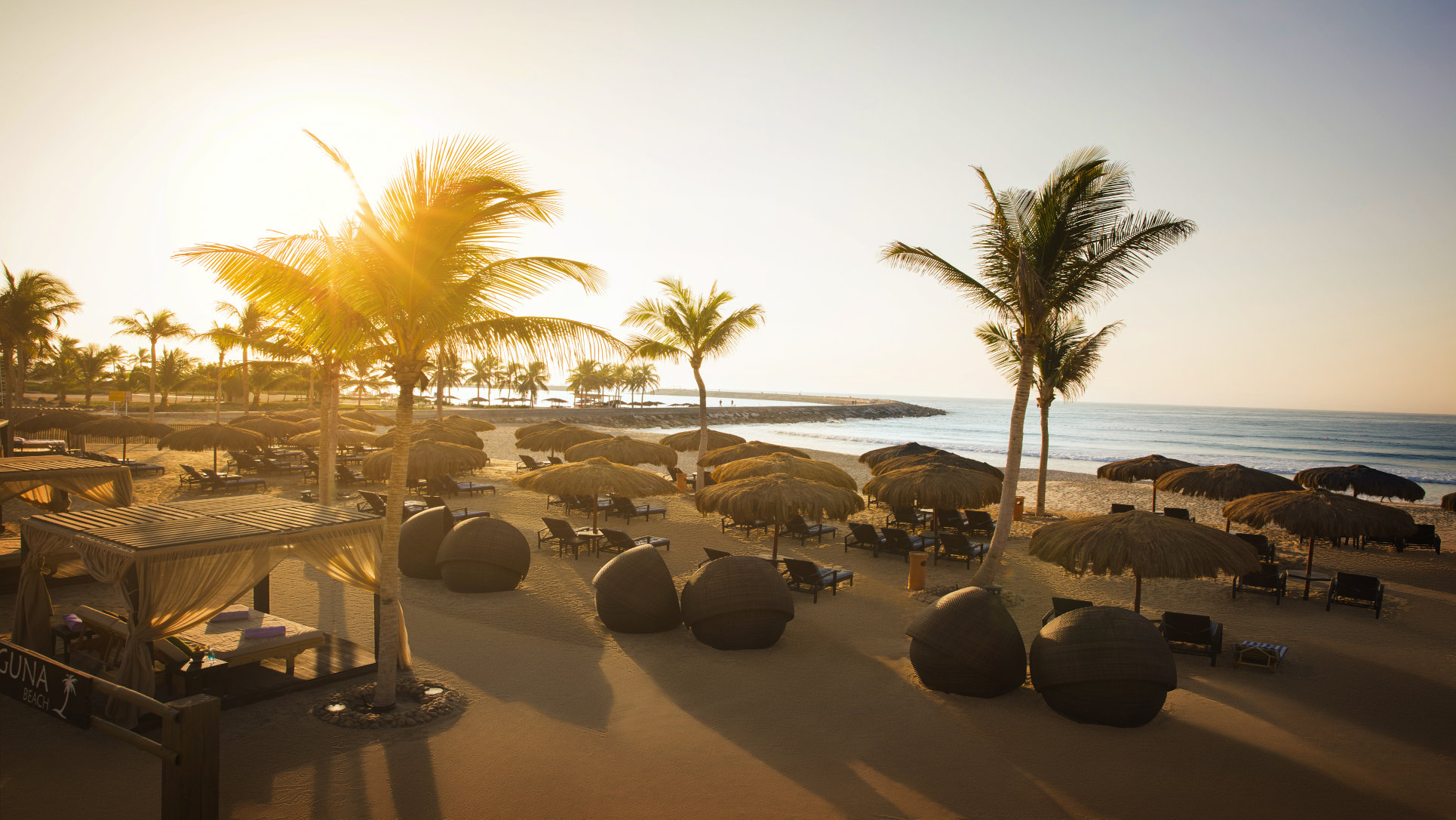 Laguna beach sunbeds and palms at Rotana Salalah Oman.