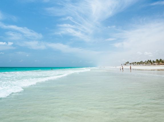 عائلة تستمتع بشواطئ صلالة الرائعة وقت موسم الخريف في صلالة