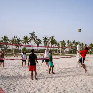 young people playing volleybal on salalah beach oman