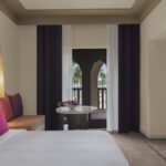 Club Rotana Spacious family room king size bed with a table and window at Rotana Salalah Oman