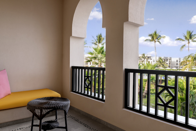 Spacious family garden view room balcony with a sofa at Rotana Salalah Oman