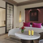 Family room with king bed and small table, bathroom on left side, at Rotana Salalah Oman
