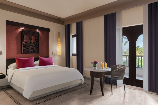 Family ocean view room with a king bed and small table at Rotana Salalah Oman