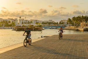 a couple enjoying bicycle riding by the marina at Hawana Salalah Oman