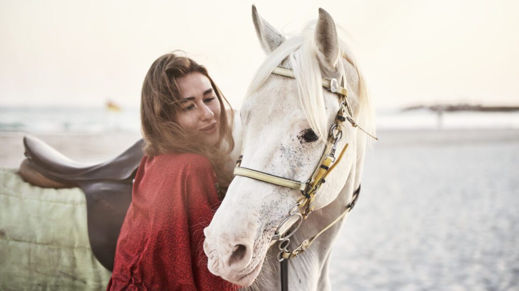 A girl petting on a horse in Salalah