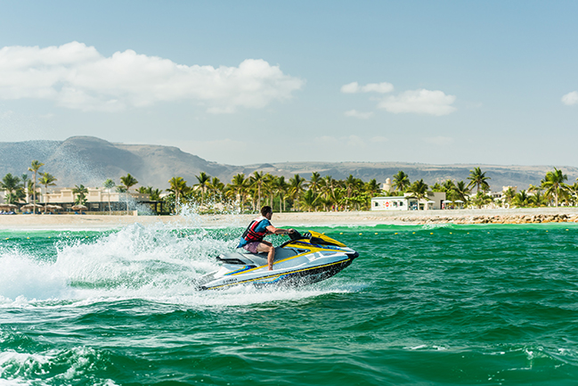 a guy enjoying his time riding a jetski at hawana salalah.