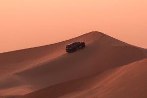 an SUV car during a Safari in the desert during sunset at Hawana Salalah