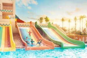 kids playing on a slider to the pool at Hawana Aquapark Salalah Oman.