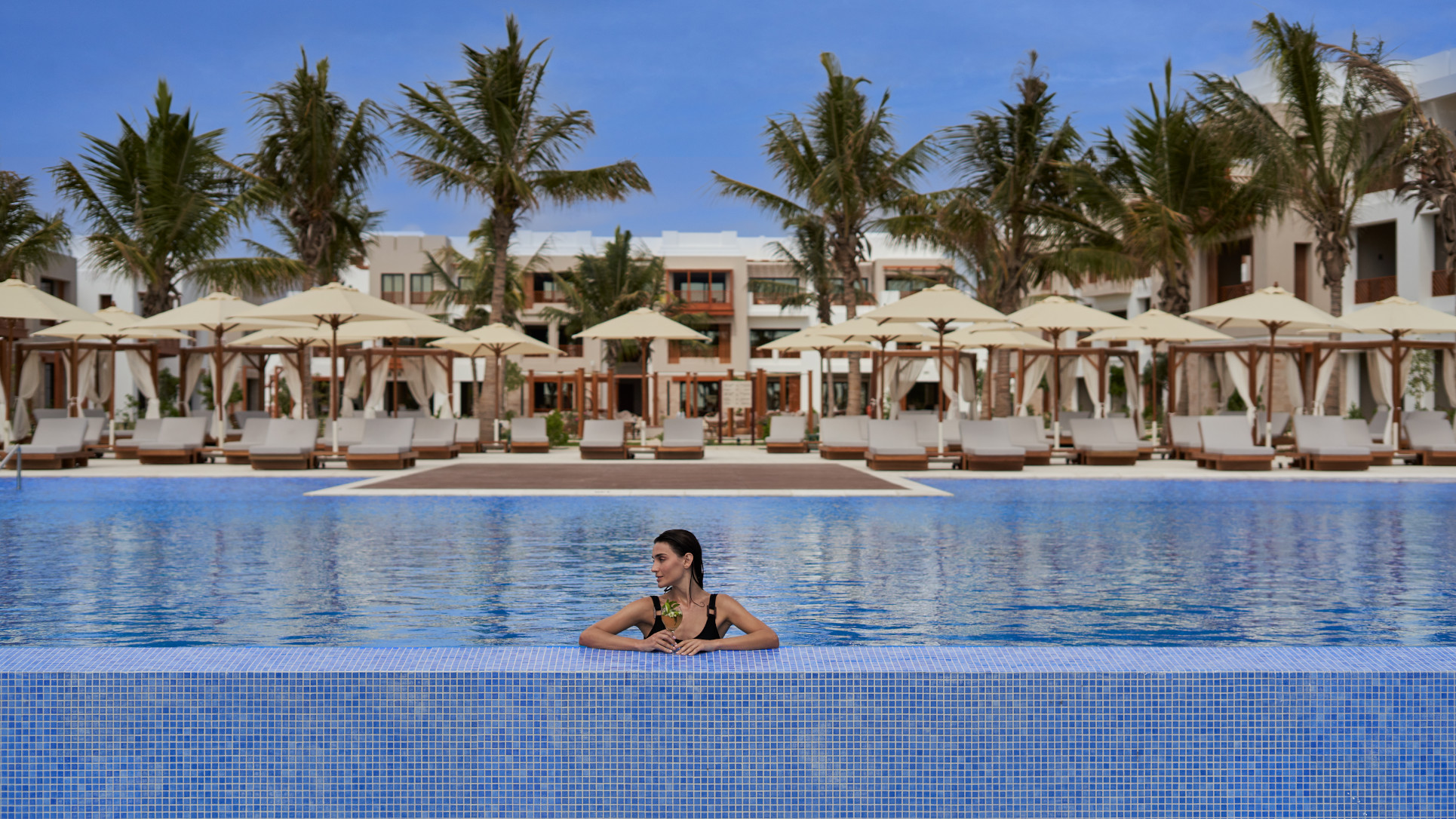 A Girl enjoying her drink resting in the pool at the Club By Fanar Hotel Salalah
