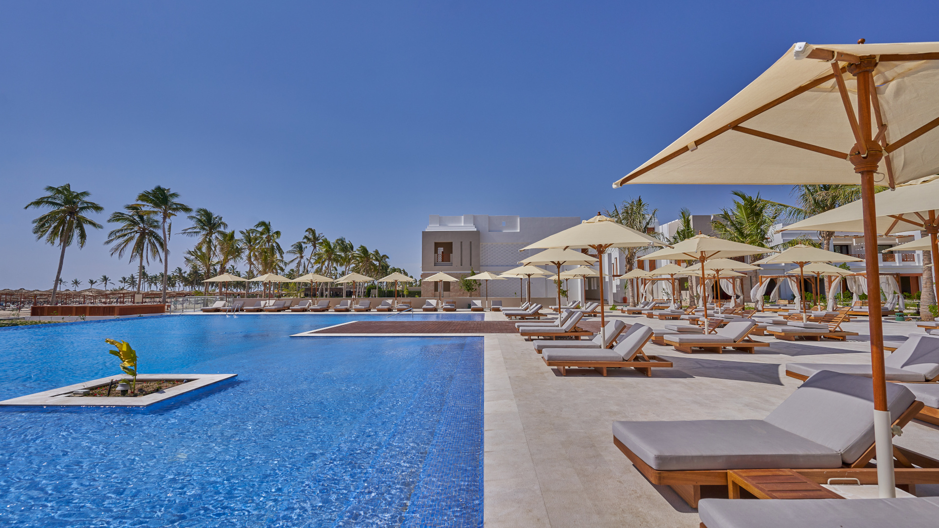 The Pool and Sunbeds during a sunny day at the Club by Fanar Hotel Salalah